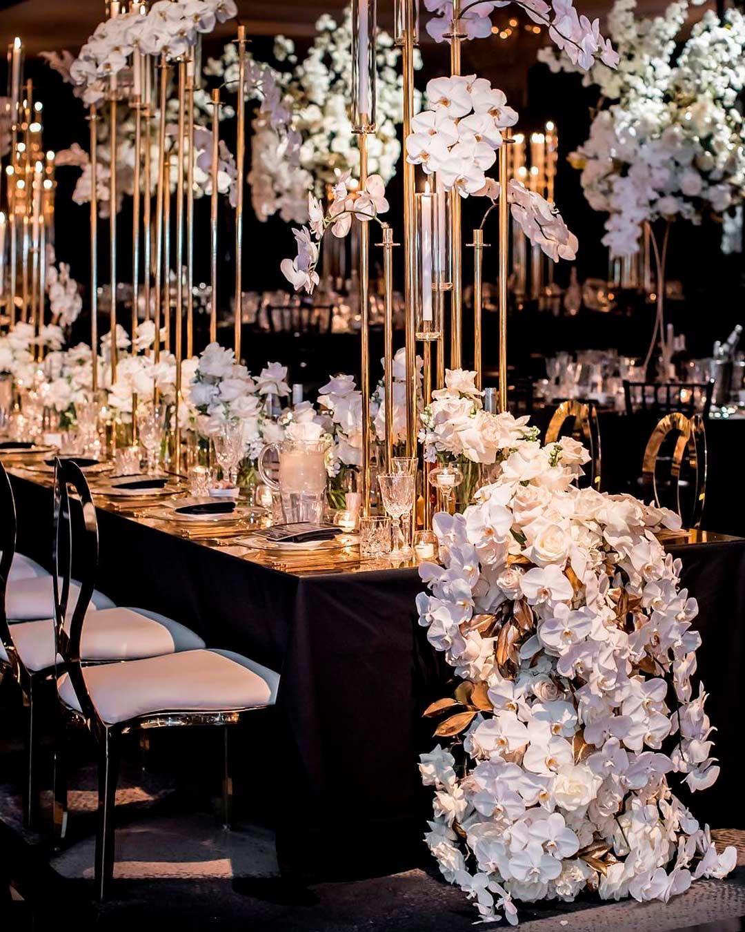 Candlelit black tablescape with white orchids and brass details